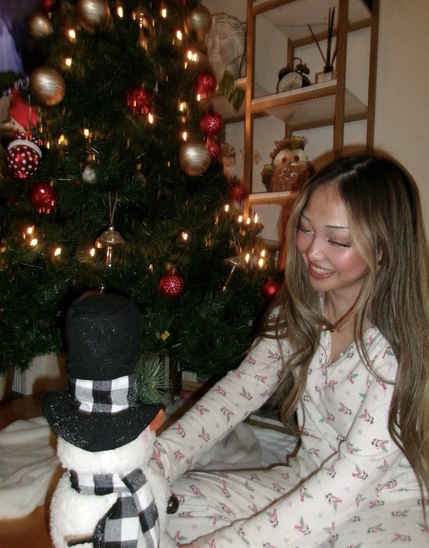 Veronika at home beside a decorated Christmas tree
